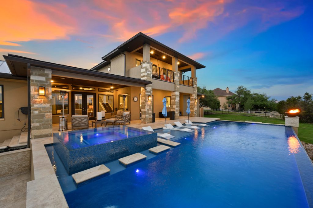 Tahoe Blue Pebble Finish with custom swimming pool and spa, glass tile with floating steps, concrete fire bowls, Cabo bench and infinity edge pool.